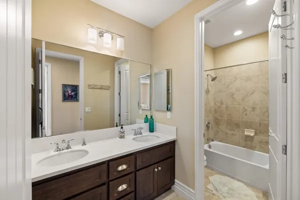 a bathroom with a double vanity sink mirror double and bathtub