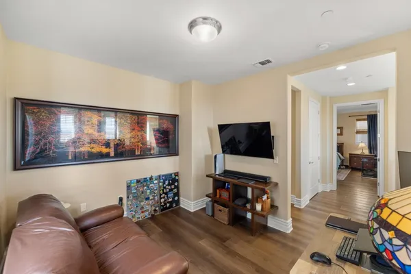 a living room with furniture and a flat screen tv with wooden floor
