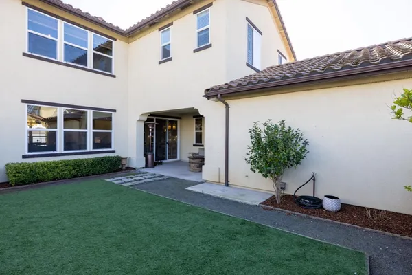 a backyard of a house with lots of green space and fountain
