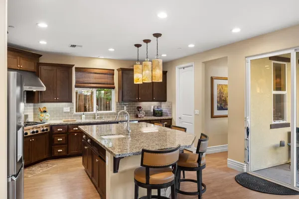 a kitchen with granite countertop a sink stove and refrigerator