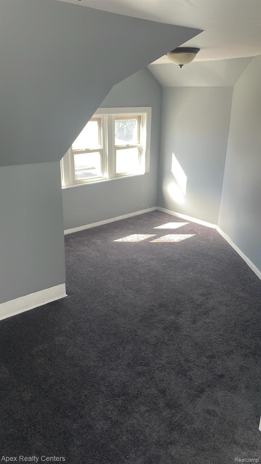 6730 Forrer Street Detroit, MI 48228 - Photo 9 of 10 Carpeted room featuring a double window, light blue wall paint, white trim, and a ceiling-mounted light fixture