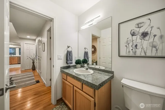 a bathroom with a granite countertop sink and a wooden floor