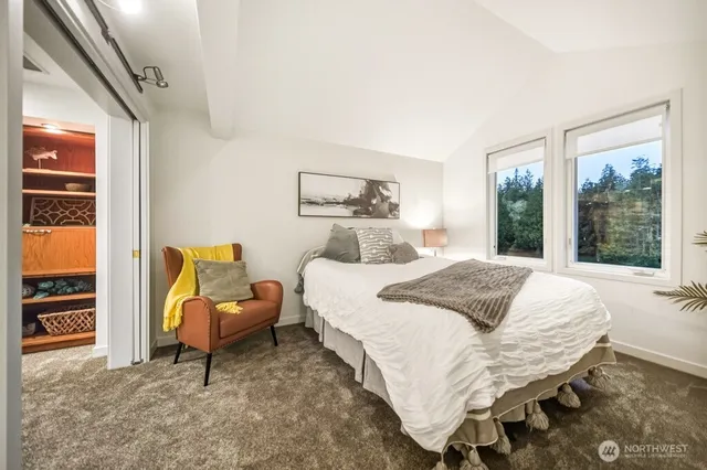 a bedroom with a bed and a large window