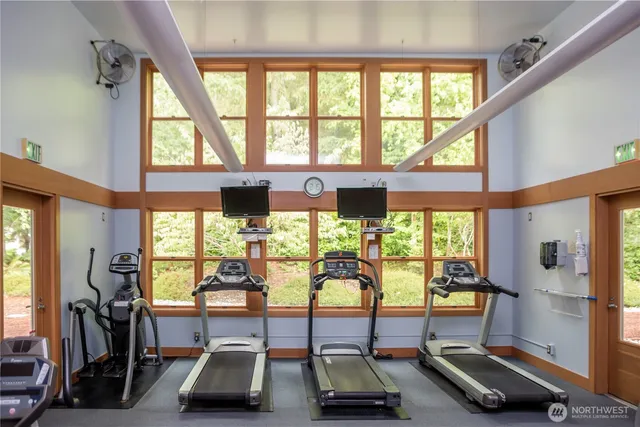 a room with gym equipment and large windows