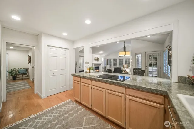 a large white kitchen with a sink and dishwasher a stove with wooden floor