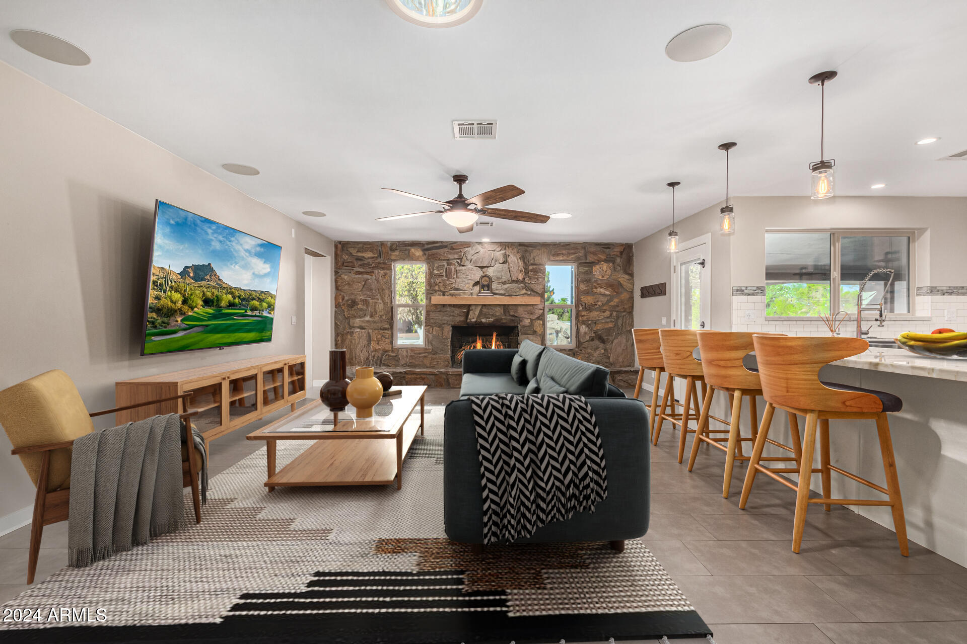 2386 East Redfield Road Gilbert, AZ 85234 - Photo 7 of 107 a living room with furniture a flat screen tv and kitchen view