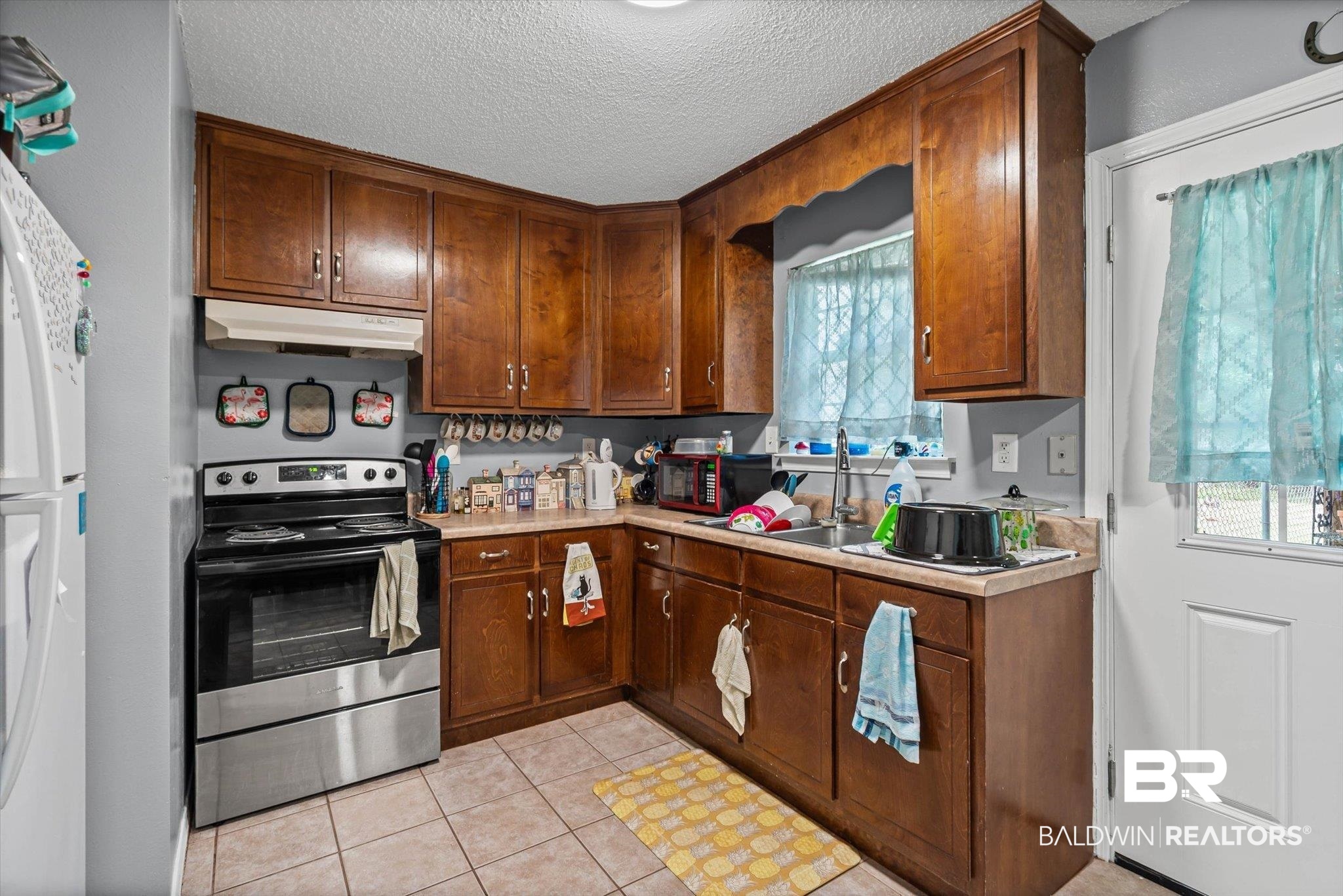 14165 River Oaks Road, Unit A & B Coden, AL 36523 - Photo 16 of 35 Kitchen featuring stainless steel electric range oven, light countertops, light tile patterned floors, a textured ceiling, and freestanding refrigerator