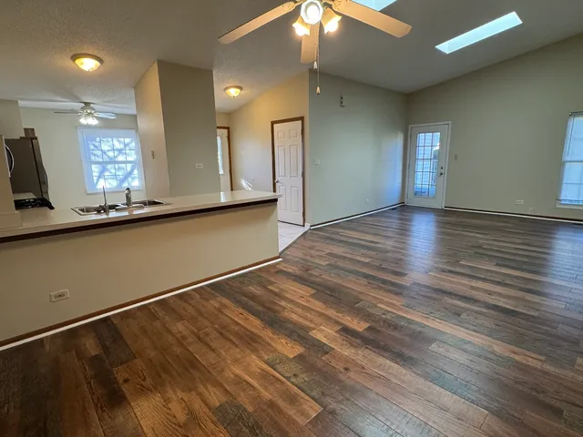 a view of a kitchen with a sink and wooden floor
