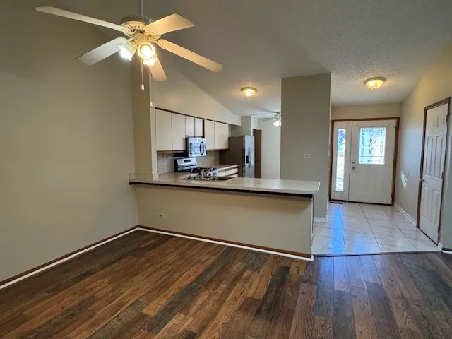 a kitchen with kitchen island white cabinets and stainless steel appliances