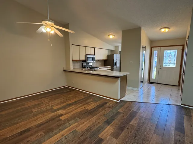 a kitchen with kitchen island granite countertop a sink cabinets and wooden floor