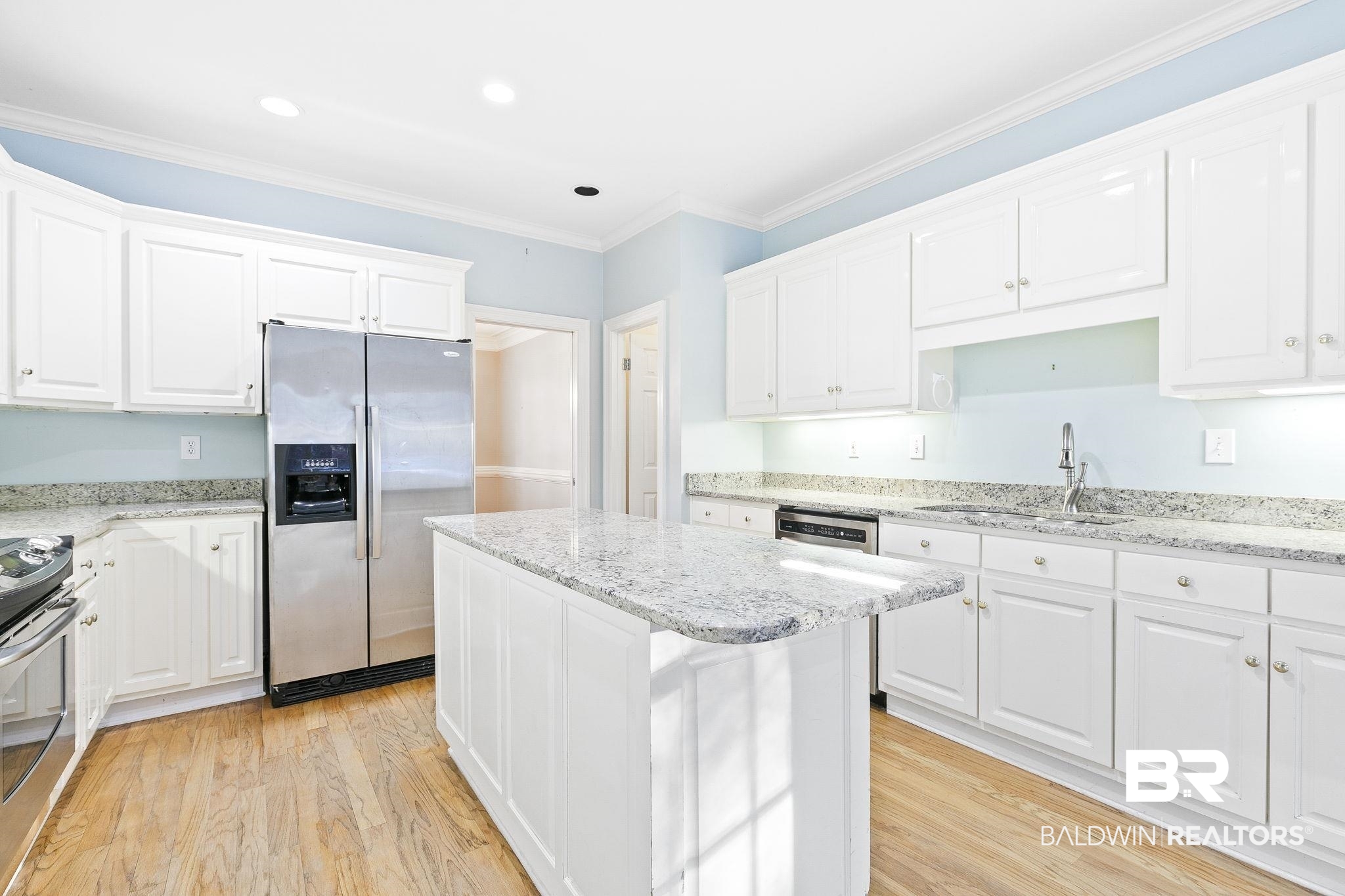 2100 Stonebrook Drive West Mobile, AL 36695 - Photo 19 of 60 Kitchen featuring white cabinets, a center island, stainless steel fridge with ice dispenser, and range