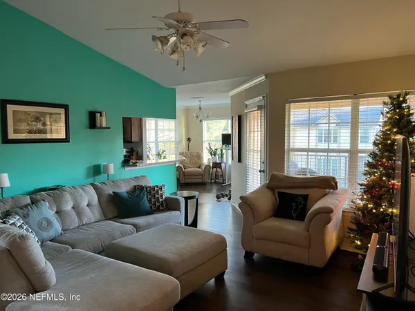a living room with furniture ceiling fan and a window