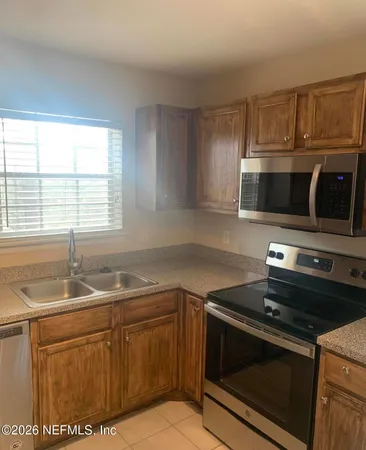 a kitchen with granite countertop a sink stove and microwave
