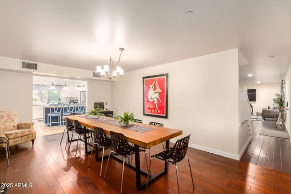 a dining area with a table chairs and a kitchen