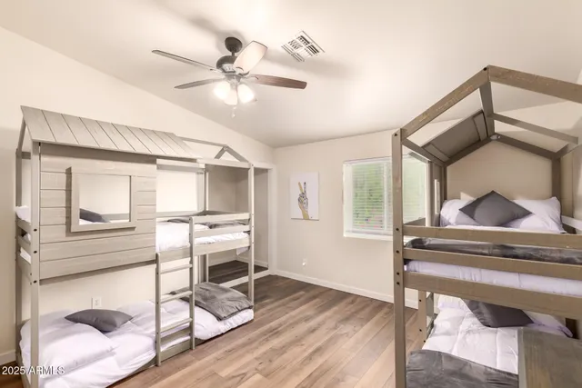 a bedroom with a bed a ceiling fan and a dresser