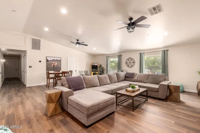 a living room with furniture and a wooden floor