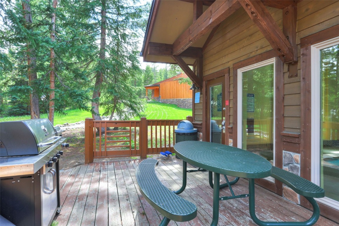 840 4 O Clock Road, Unit A1D Breckenridge, CO 80424 - Photo 37 of 38 a view of a patio with table and chairs potted plants with wooden floor and fence