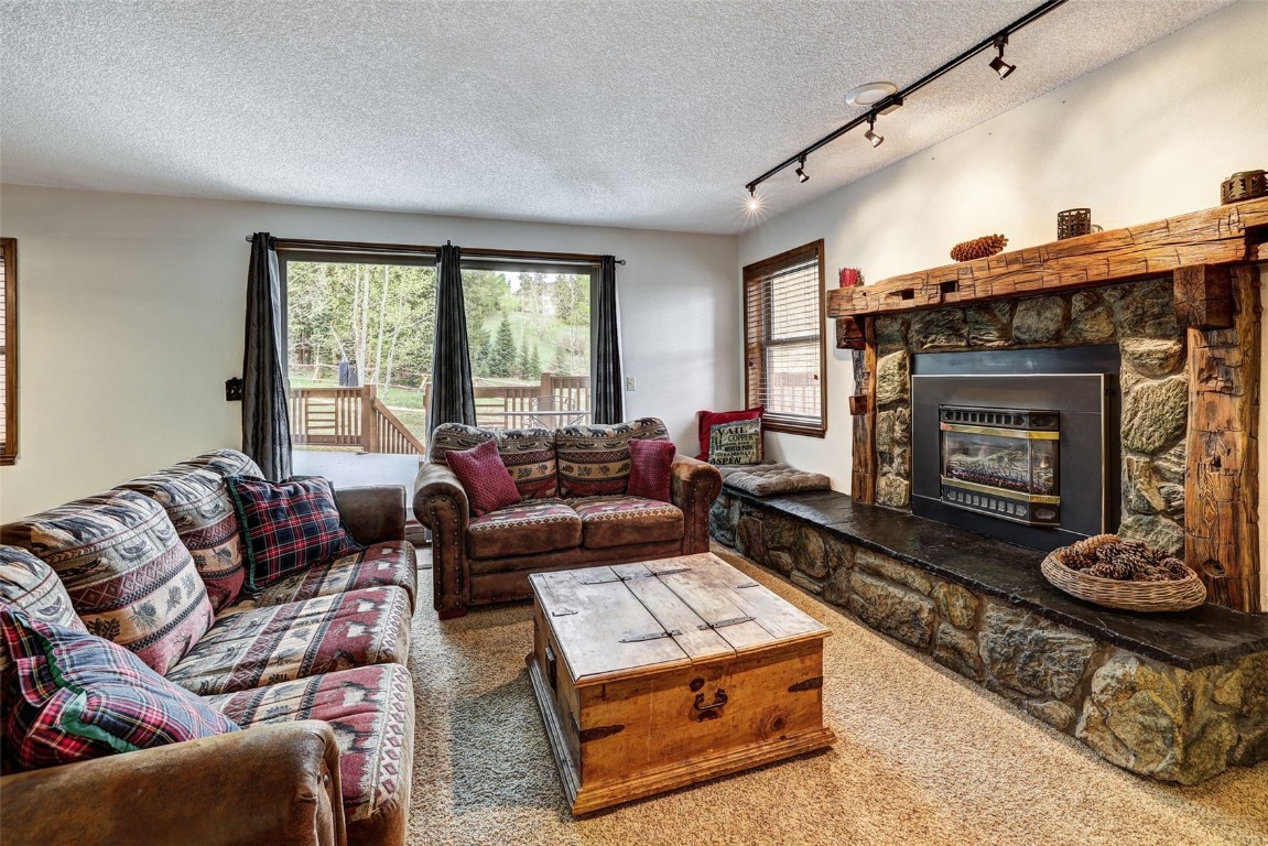840 4 O Clock Road, Unit A1D Breckenridge, CO 80424 - Photo 4 of 38 a living room with furniture a fireplace and a large window
