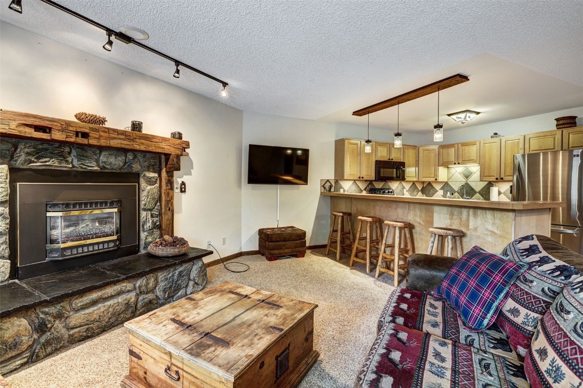 840 4 O Clock Road, Unit A1D Breckenridge, CO 80424 - Photo 5 of 38 a living room with furniture and a fireplace