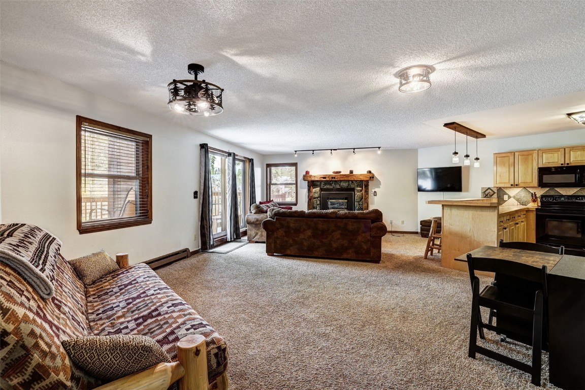840 4 O Clock Road, Unit A1D Breckenridge, CO 80424 - Photo 6 of 38 a living room with furniture a flat screen tv and kitchen view