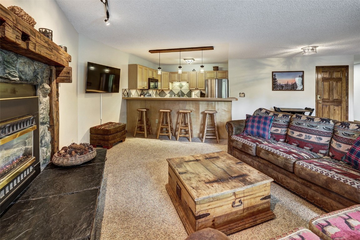 840 4 O Clock Road, Unit A1D Breckenridge, CO 80424 - Photo 7 of 38 a living room with furniture and a flat screen tv
