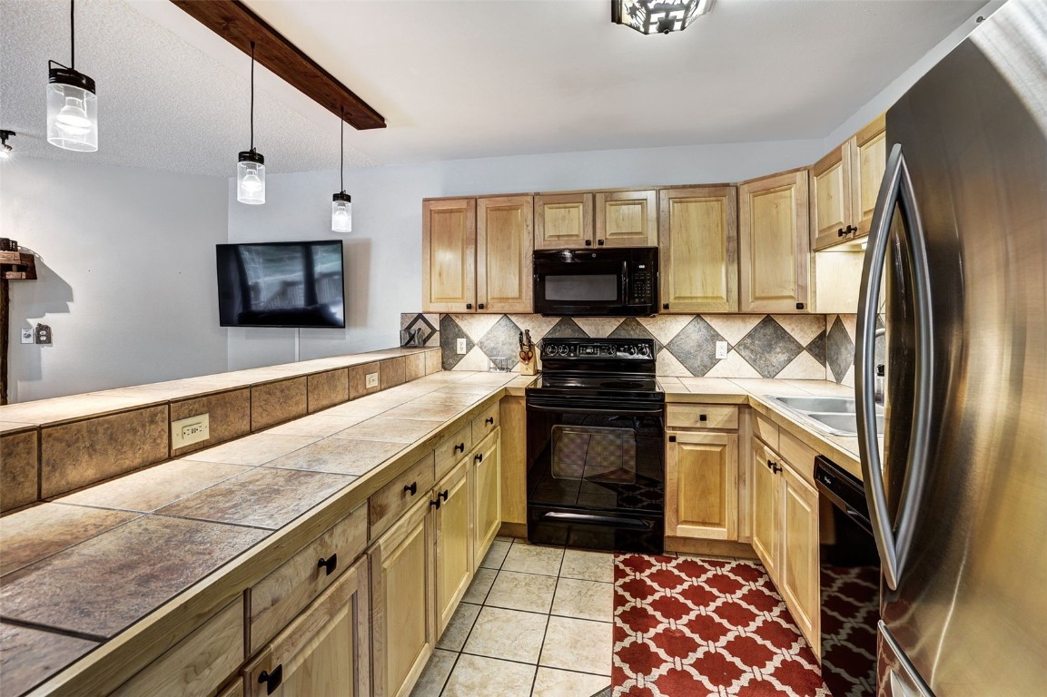 840 4 O Clock Road, Unit A1D Breckenridge, CO 80424 - Photo 9 of 38 a kitchen with stainless steel appliances a refrigerator sink and stove
