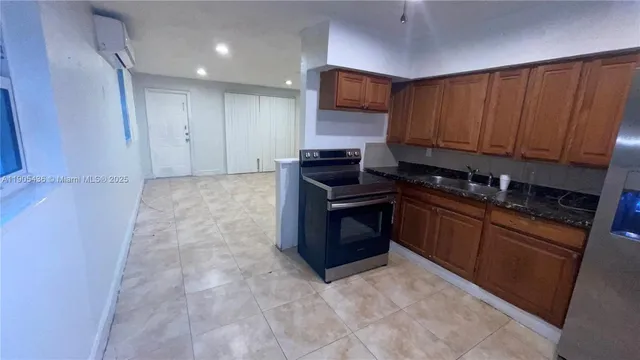 a kitchen with stainless steel appliances granite countertop a stove a sink and a refrigerator