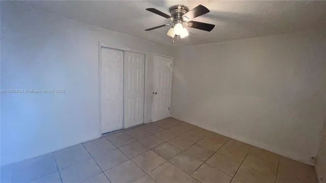 an empty room with a ceiling fan and a window