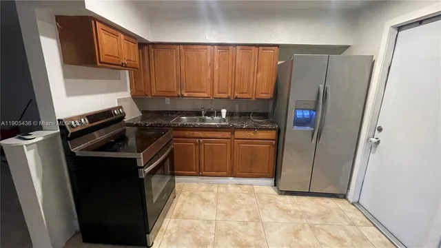 a kitchen with a sink a stove and a refrigerator