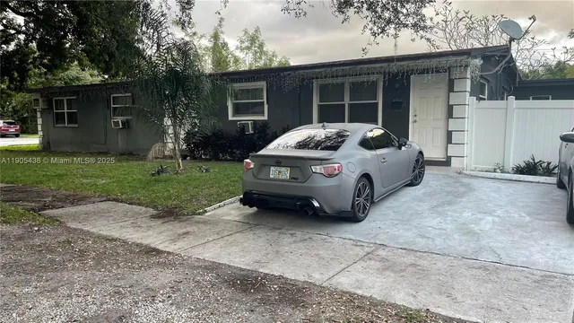 a car parked in front of white house