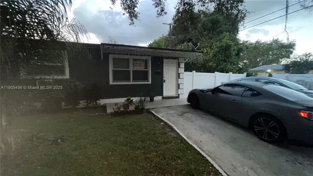 a couple of cars parked in front of a house