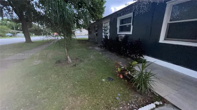 a backyard of a house with flower plants