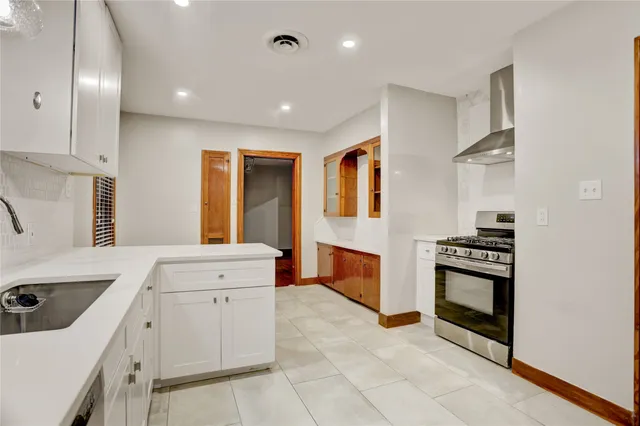 a kitchen with a stove sink and cabinets