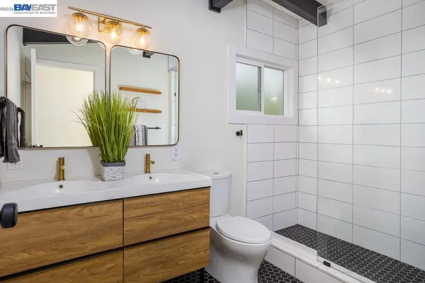 a bathroom with a granite countertop sink a toilet and mirror