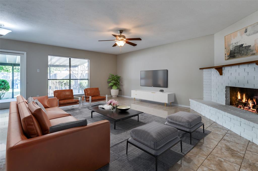 10257 Sweet Gum Street Dallas, TX 75249 - Photo 3 of 29 a living room with furniture a flat screen tv and a fireplace