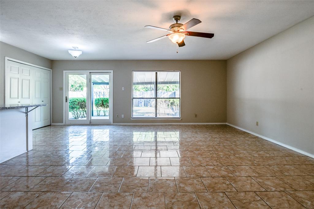 10257 Sweet Gum Street Dallas, TX 75249 - Photo 5 of 29 an empty room with windows and ceiling fan