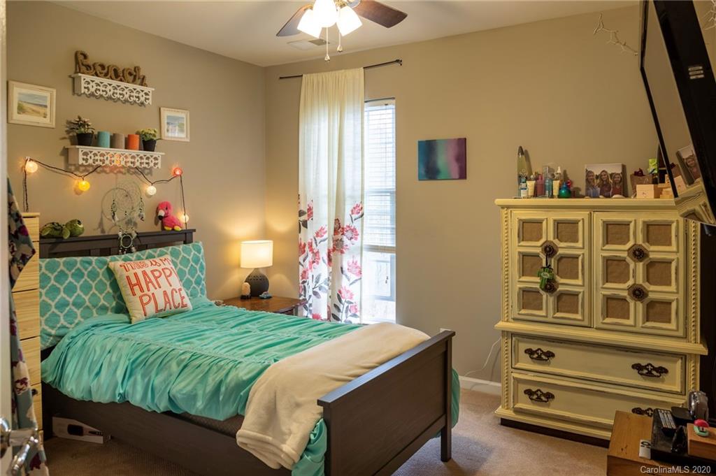 564 6th Baxter Crossing, Unit 13 Fort Mill, SC 29708 - Photo 13 of 39 a bedroom with a bed and a chandelier