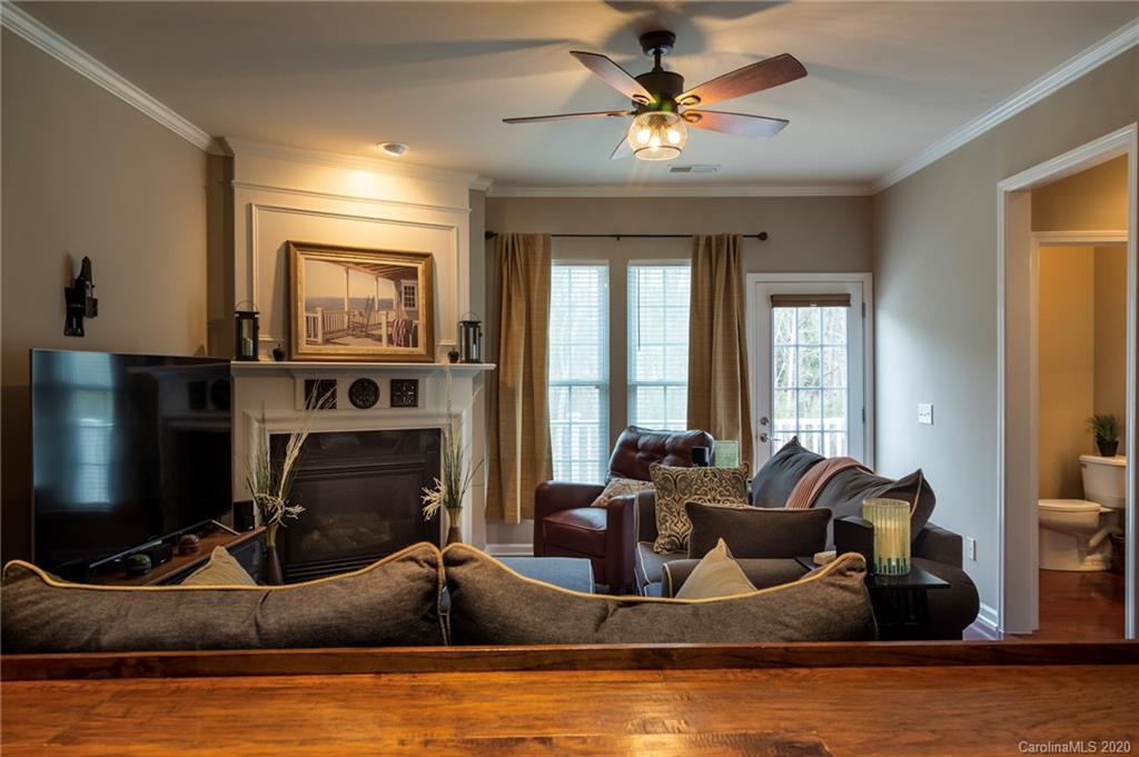 564 6th Baxter Crossing, Unit 13 Fort Mill, SC 29708 - Photo 4 of 39 a living room with furniture a flat screen tv and a fireplace