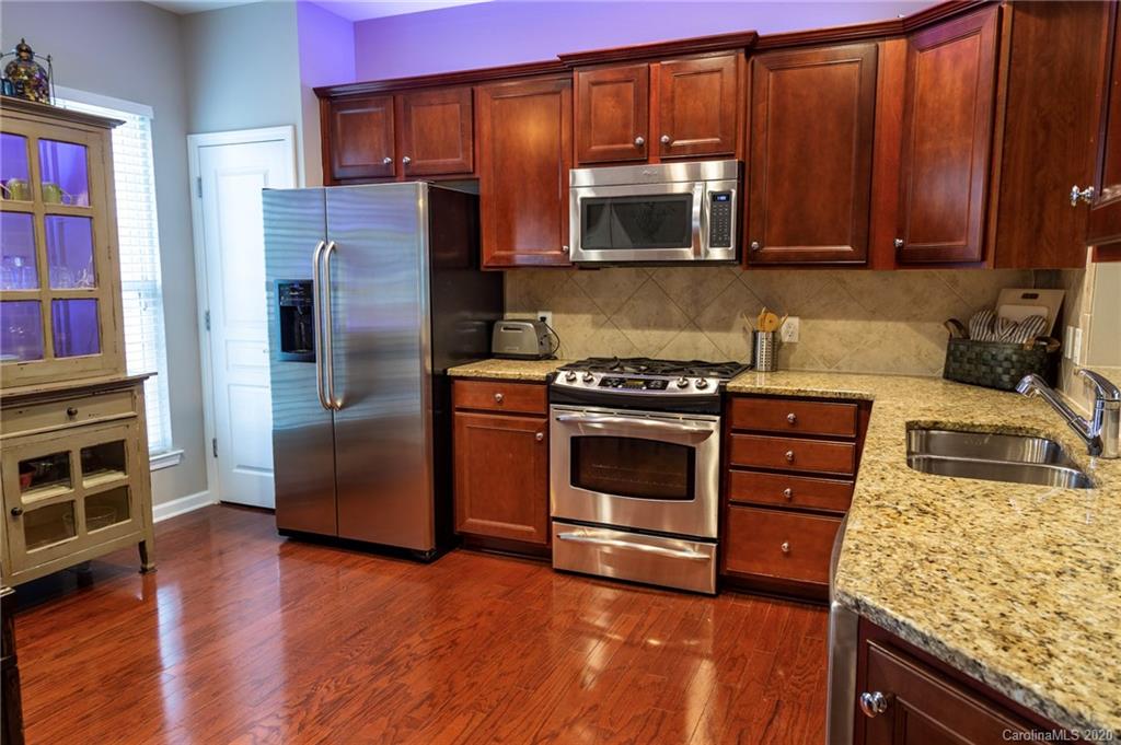 564 6th Baxter Crossing, Unit 13 Fort Mill, SC 29708 - Photo 6 of 39 a kitchen with granite countertop a stove and a microwave oven