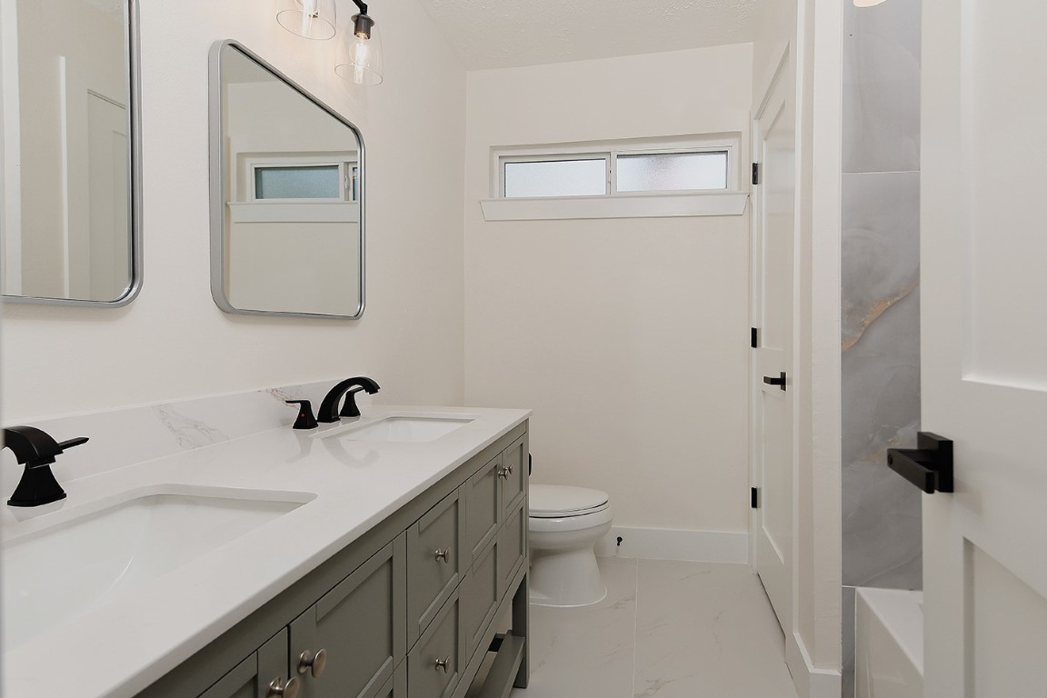 16 Crinkleroot Court The Woodlands, TX 77380 - Photo 29 of 36 a bathroom with a sink toilet and mirror