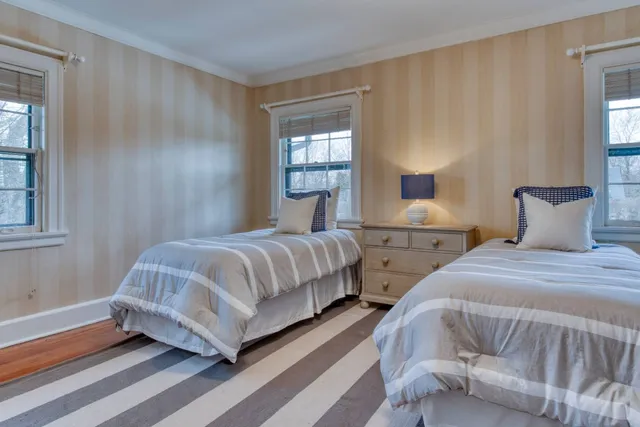 a bedroom with two beds and a window