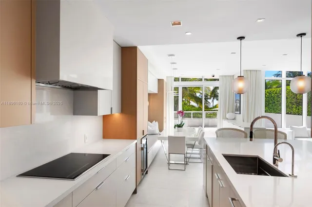 a kitchen with stainless steel appliances a sink a stove a refrigerator a counter top oven and cabinets