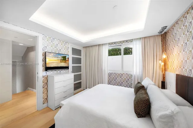 a bedroom with a bed and a flat screen tv