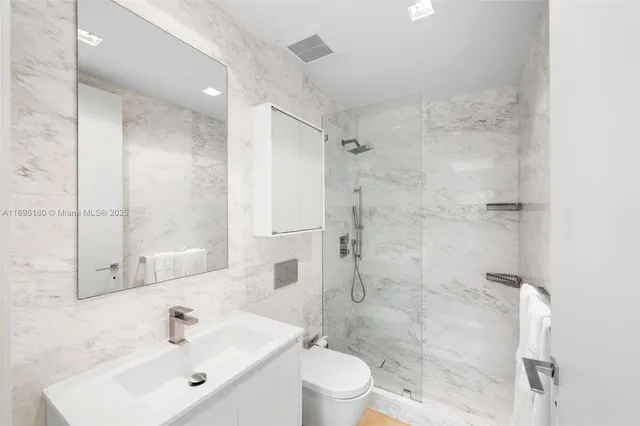 a bathroom with a sink shower and a toilet