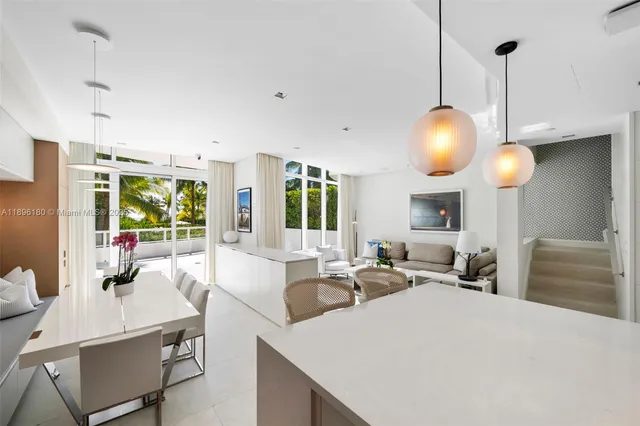 a large room with kitchen island a large window a sink and living room view