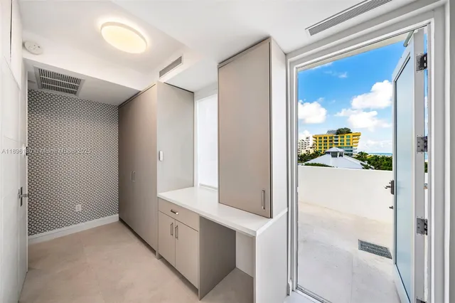 a view of a white building with a yard