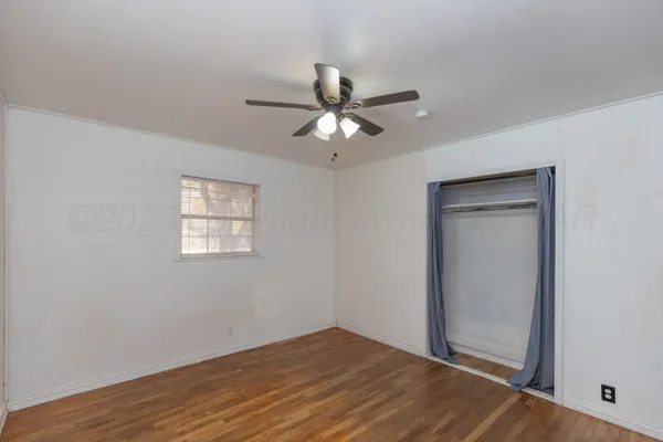 a view of a room with a ceiling fan and a window