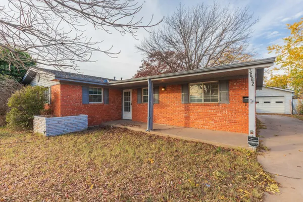 a view of a house with a yard and large tree