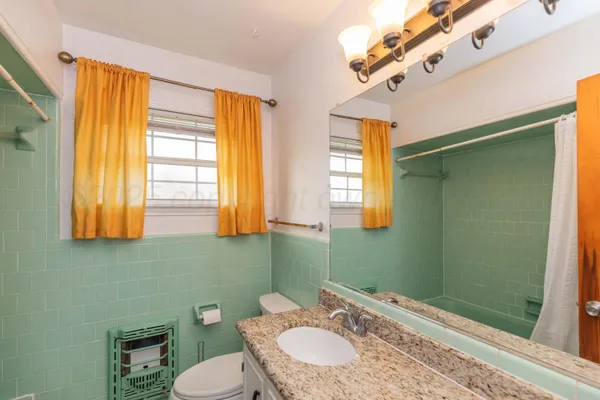 a bathroom with a sink a toilet and a mirror