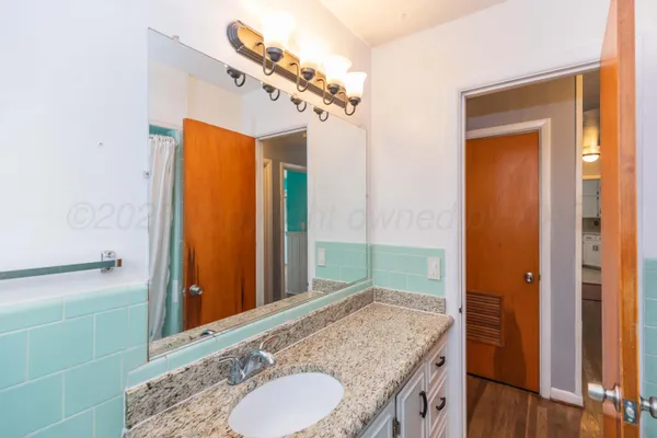 a bathroom with a granite countertop sink and a mirror